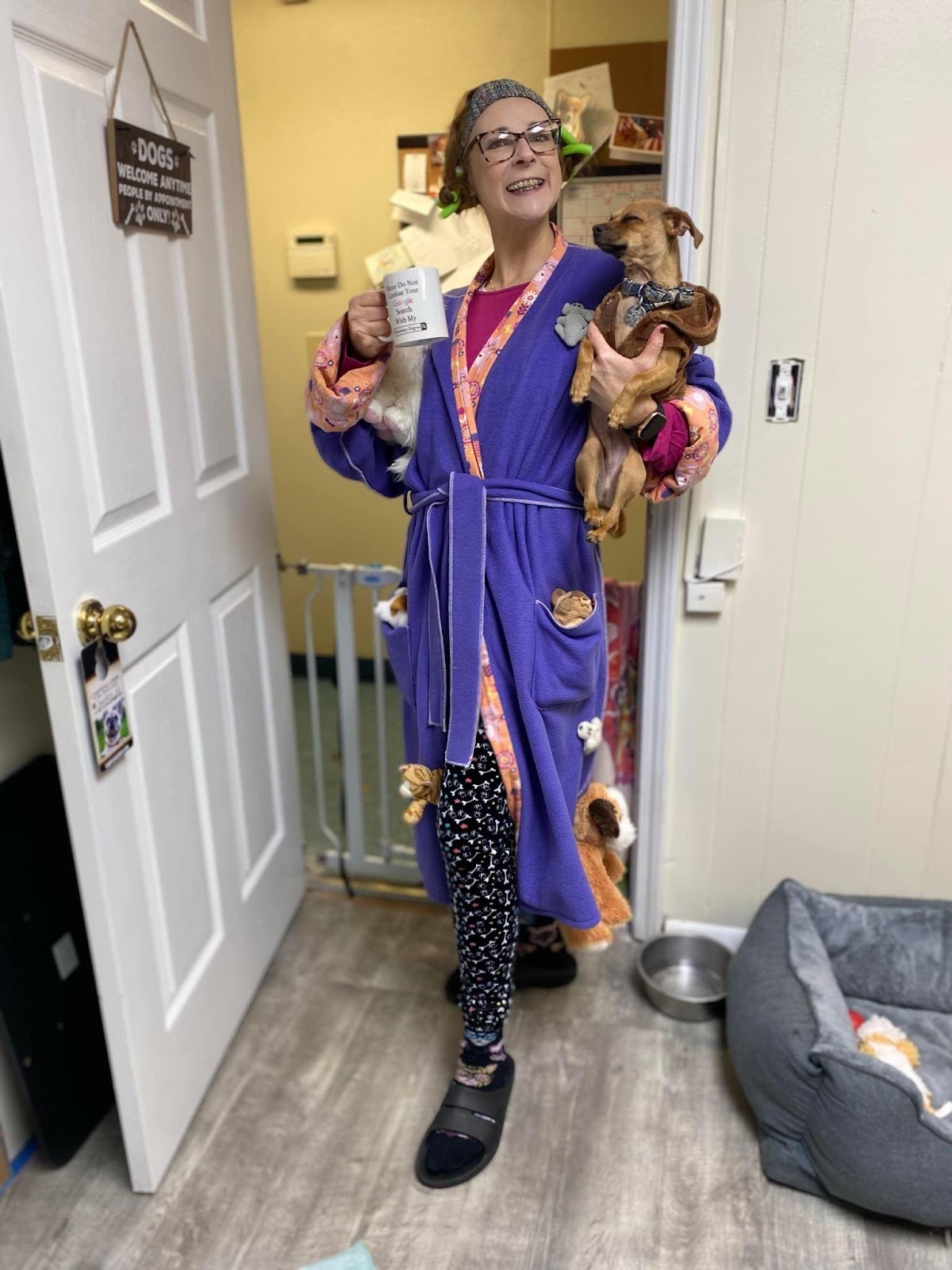 A woman in a purple robe holding stuffed animals.