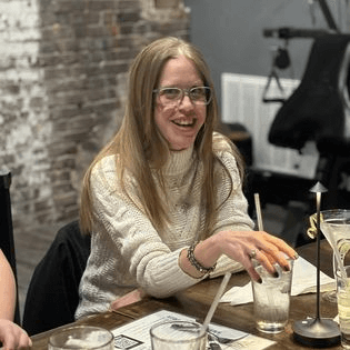 Two women sitting at a table laughing.