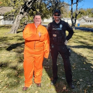 Two police officers in orange uniforms standing next to each other.