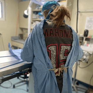 A woman wearing a shirt with a number on it in an operating room.